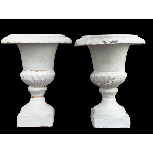 121 - A SMALL PAIR OF CAST IRON URNS CANDLE STANDS