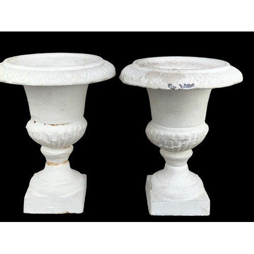 121 - A SMALL PAIR OF CAST IRON URNS CANDLE STANDS