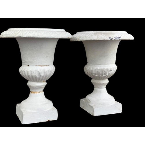 121 - A SMALL PAIR OF CAST IRON URNS CANDLE STANDS