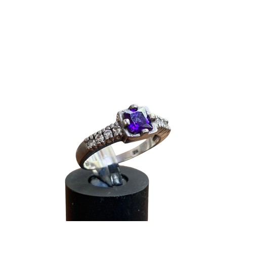 295 - A SILVER GEM SET SILVER RING SET WITH PURPLE STONE