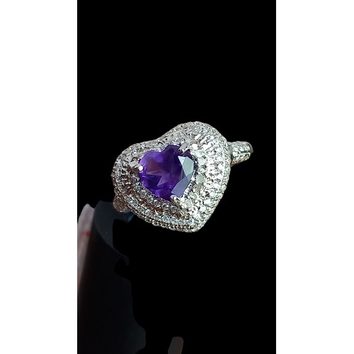 306 - A SILVER HEART RING SET WITH AN AMETHYST STONE