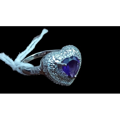 306 - A SILVER HEART RING SET WITH AN AMETHYST STONE