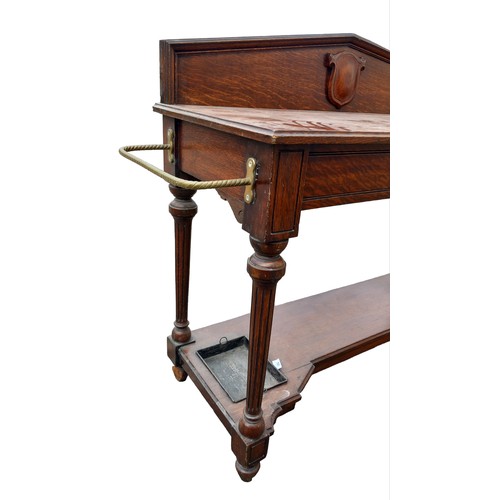 125A - AN ANTIQUE OAK SINGLE DRAWER CONSO; TABLE WITH BRASS STICKSTAND RAIL THE MOULDED GALLERY BACK HAS A ... 