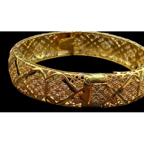 215 - A BOXED ORIENTAL GILT BANGLE