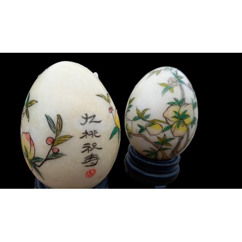 336 - 2 ORIENTAL HANDPAINTED MARBLE EGGS ON STANDS