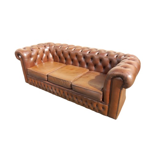 406 - A BROWN LEATHER BUTTON BACK SETTEE (SOME DAMAGE TO SIDE )