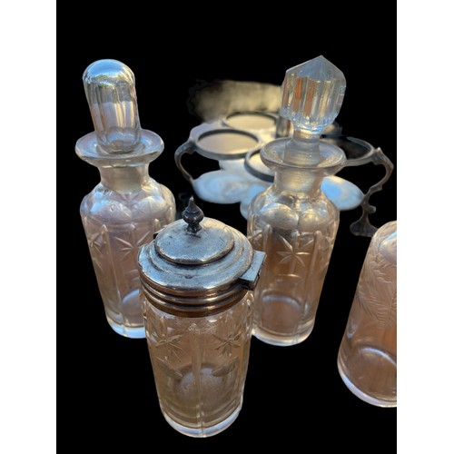 376 - AN ANTIQUE CUT GLASS AND ETCHED CRUET SET IN A PLATED HOLDER