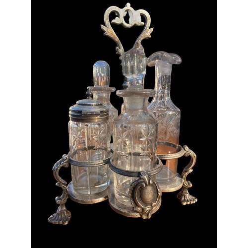 376 - AN ANTIQUE CUT GLASS AND ETCHED CRUET SET IN A PLATED HOLDER