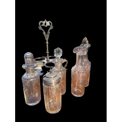 376 - AN ANTIQUE CUT GLASS AND ETCHED CRUET SET IN A PLATED HOLDER