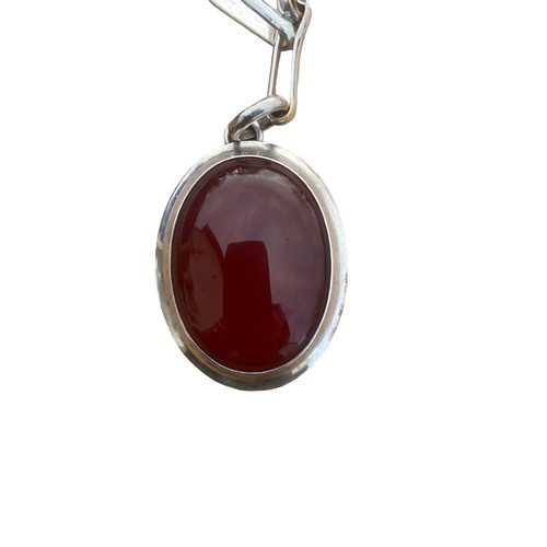 574 - A STUNNING SILVER MOUNTED CORNELIAN STONE PENDANT ON A LARGE LONG FANCY LINK WHITE METAL CHAIN