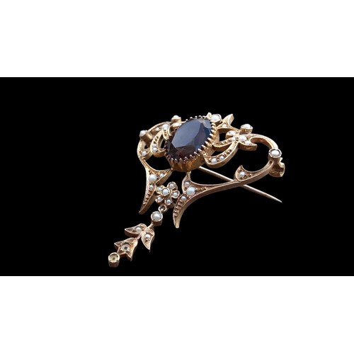 621 - A 9ct GOLD BROOCH WITH CENTRE OVAL SMOKEY QUARTZ AND SEED PEARLS WITH DROP GOLD PIN WITH SCROLL SAFE... 