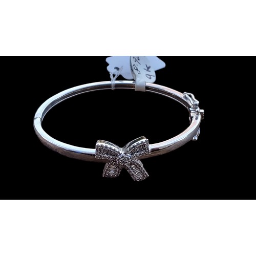 653 - A CHILDS 9ct WHITE GOLD BANGLE SET WITH DIAMONDS BOW TO CENTRE (BAGUETTE & BRILLIANT CUT DIAMONDS) P... 