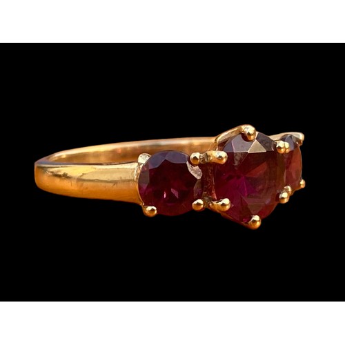 663 - A 9CT GOLD RING SET WITH 3 RUBY STYLE STONES WITH DIAMOND CHIPS TO THE OUTSIDE OF THE SETTING