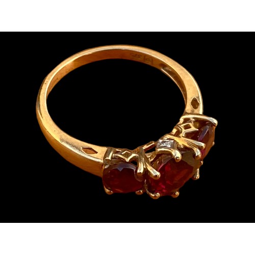 663 - A 9CT GOLD RING SET WITH 3 RUBY STYLE STONES WITH DIAMOND CHIPS TO THE OUTSIDE OF THE SETTING