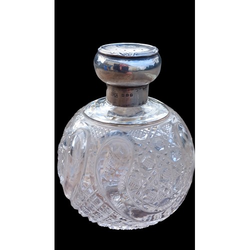 685 - A BEAUTIFULLY CUT GLASS PERFUME BOTTLE WITH STOPPER AND AN ORNATE LONDON SILVER TOP BY WAPPIN & WEBB