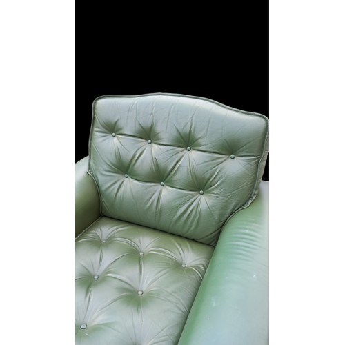 500 - A GREEN LEATHER BUTTONED ARMCHAIR IN RETRO STYLE FINISH