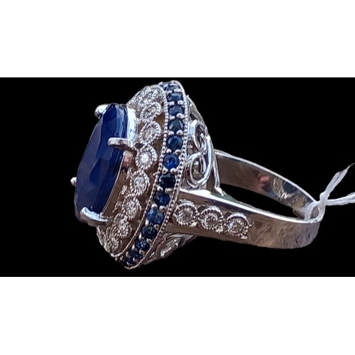 675 - A LARGE OVAL SAPPHIRE AND DIAMOND RING A CENTRE SAPPHIRE WITH OUTER ROW OF 18 DIAMONDS AND A ROW OF ... 