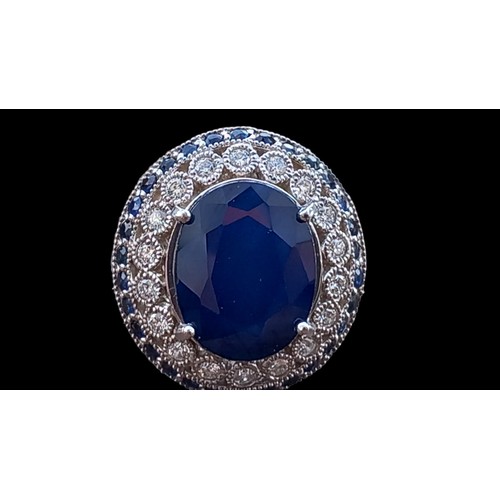 675 - A LARGE OVAL SAPPHIRE AND DIAMOND RING A CENTRE SAPPHIRE WITH OUTER ROW OF 18 DIAMONDS AND A ROW OF ... 