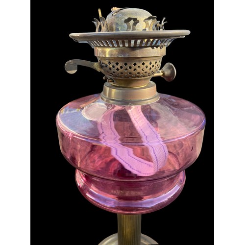 716 - A VICTORIAN RUBY BOLWED OIL LAMP WITH A BRASS BASE