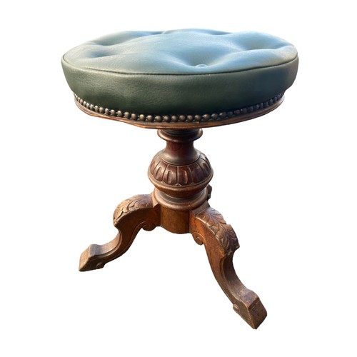 700A - ANTIQUE REVOLVING STOOL WITH A GREEN LEATHER BUTTON TOP AND CARVED TRI POD BASE