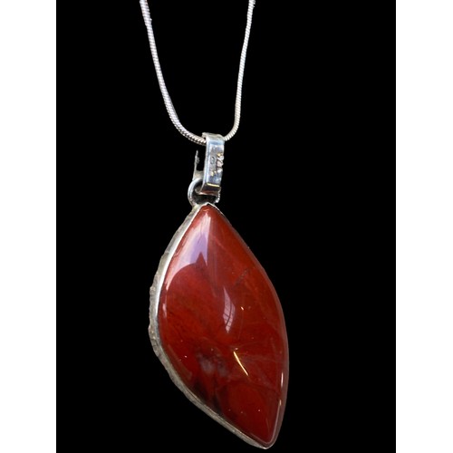 490A - A LARGE SILVER CORNELAIN STONE PENDANT ON A SILVER CHAIN