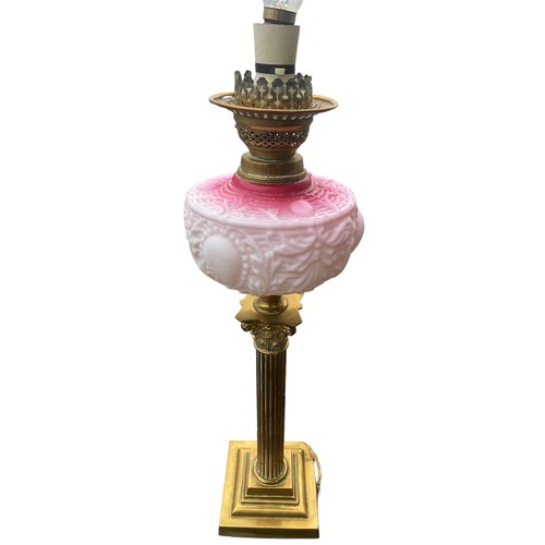 158 - A BEAUTIFULLY EMBOSSED RUBY BOWL OIL LAMP ON A BRASS PILLAR CONVERTED TO ELECTRIC