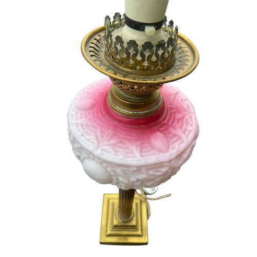 158 - A BEAUTIFULLY EMBOSSED RUBY BOWL OIL LAMP ON A BRASS PILLAR CONVERTED TO ELECTRIC