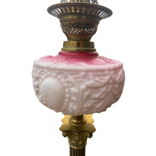 158 - A BEAUTIFULLY EMBOSSED RUBY BOWL OIL LAMP ON A BRASS PILLAR CONVERTED TO ELECTRIC