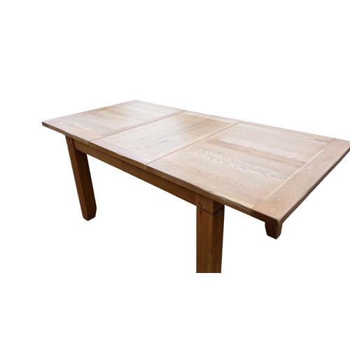 393 - A SOLID OAK EXTENDING DINING TABLE MEASURES