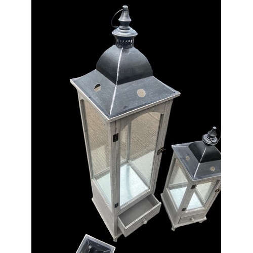 403 - A NEW SET OF 3 GRADUATED GREY FINISH CANDLE LANTERNS 2 OF WHICH HAVE DRAWRS TALLEST 48