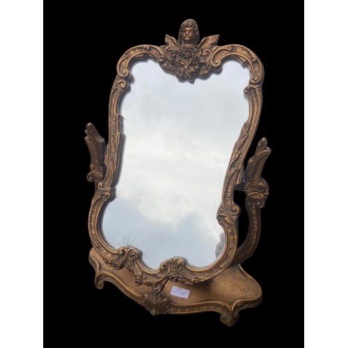 639 - AN ORNATE GILT FINISHED DRESSING MIRROR WITH CHERUB TO THE TOP