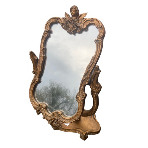 639 - AN ORNATE GILT FINISHED DRESSING MIRROR WITH CHERUB TO THE TOP