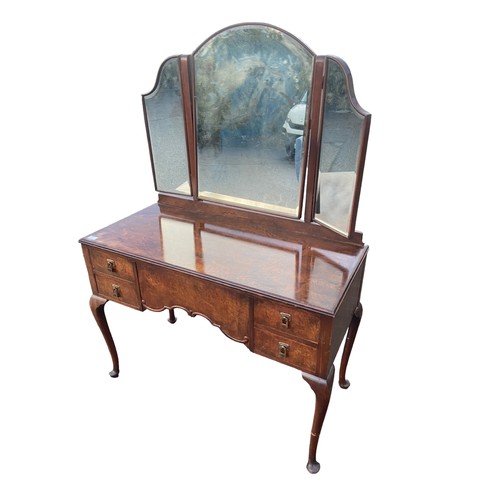 655 - A BEAUTIFULLY SHAPPED 5 DRAWERED WALNUT DRESSING TABLE WITH A BEVELLED EDGED GULL WING MIRROR