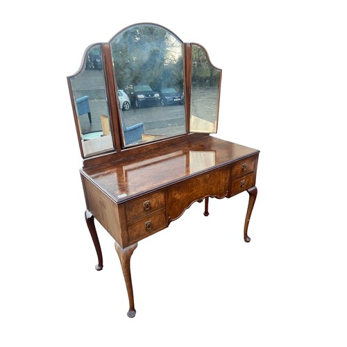 655 - A BEAUTIFULLY SHAPPED 5 DRAWERED WALNUT DRESSING TABLE WITH A BEVELLED EDGED GULL WING MIRROR