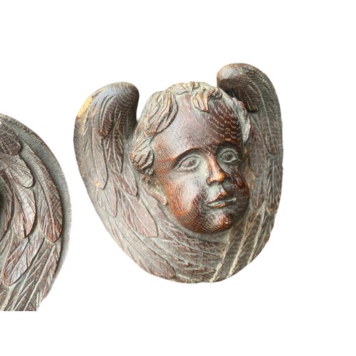 215 - A PAIR OF HEAVILY CARVED CHERUBS IN OAK APPROX 4.5