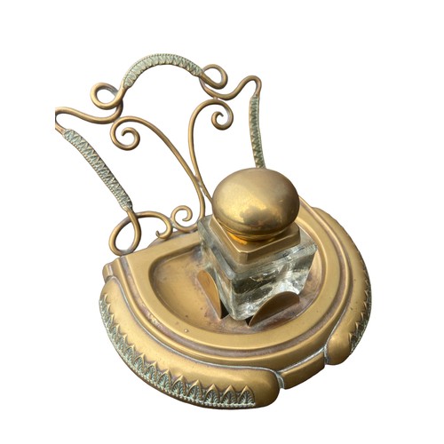 256 - AN ORNATE BRASS INKWELL STAND COMPLETE WITH AN INKWELL