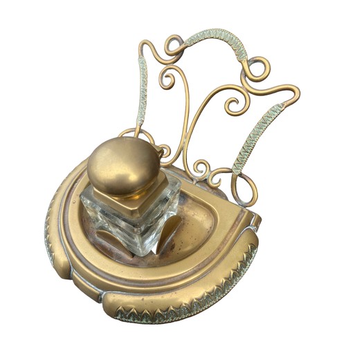 256 - AN ORNATE BRASS INKWELL STAND COMPLETE WITH AN INKWELL