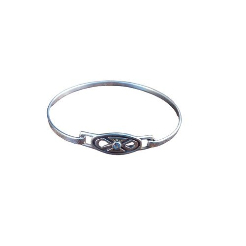 391 - A SILVER HINGED BRACELET IN A CELTIC STYLE SET WITH A AQUAMARINE STONE N