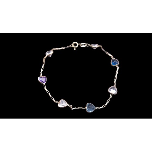 474 - AN 18ct GOLD BRACELET SET WITH HEARTS IN STONES OF SAPPHHIRE ,TOPAZ,AMETHYST AND 4 CLEAR STONES