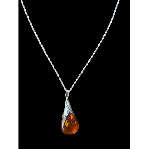 554 - A SILVER & AMBER PENDANT ON A SILVER CHAIN