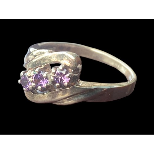 177 - AN ORNATE TWIST SILVER RING SET WITH AMETHYST