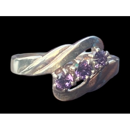 177 - AN ORNATE TWIST SILVER RING SET WITH AMETHYST