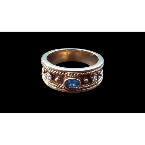 550 - A SOLID GRADUATED BAND 9CT RING SET WITH AN OVAL SAPPHIRE & 2 DIAMONDS IN A RUBOVER SETTING WITH OUT... 