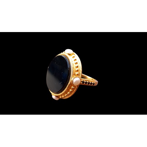 553 - A LARGE OVAL BLACK STONE RING 4 PEARLS TO THE OUTER MOUNT & BLACK STONES TO SHOULDER