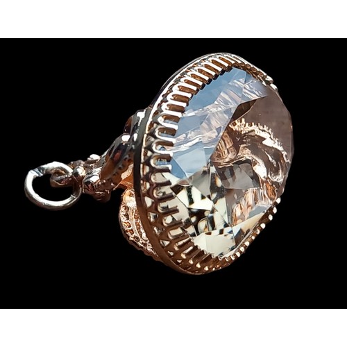 581 - A 9cct GOLD FOB 3cm LENGTH WITH QUARTZ STONE IN SCROLL MOUNT