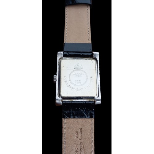 567 - A ROTARY WATCH RETANGULAR WHITE DIAL & DATE WINDOW WORKING ORDER QUARTZ ON BLACK STRAP