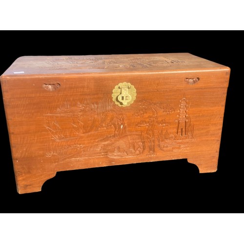 382 - AN ORIENTAL CARVED TRUNK WITH A BRASS LATCH