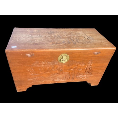 382 - AN ORIENTAL CARVED TRUNK WITH A BRASS LATCH