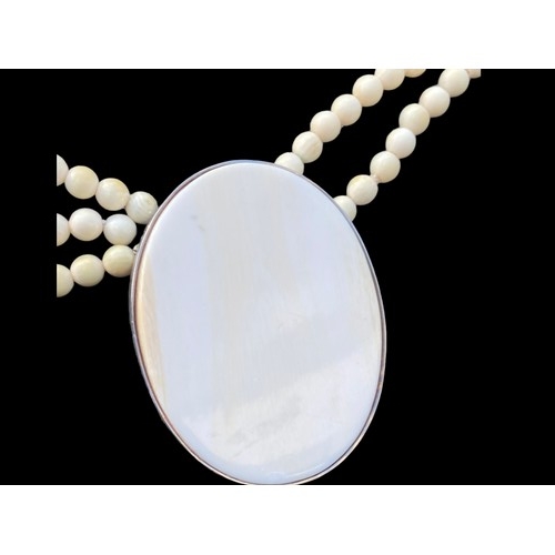 441 - A LONG TURQUOISE AND IVORY COLOUR JADE STYLE NECKLACE WITH LARGE IVORY JADE SILVER PENDANT