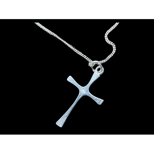 218 - A SHAPED SILVER CROSS ON A SILVER CHAIN